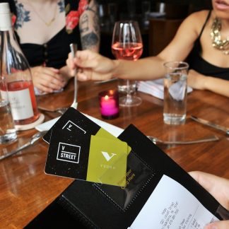 Check presenter with two vedge giftcards presented while other guests enjoy dessert