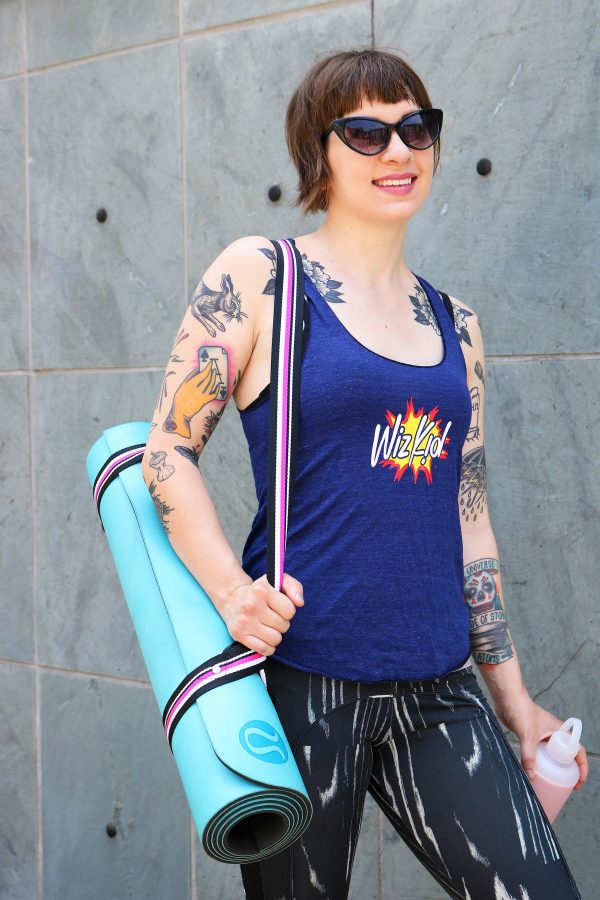 Model wearing blue wiz kid tank top with yoga mat strapped to shoulder